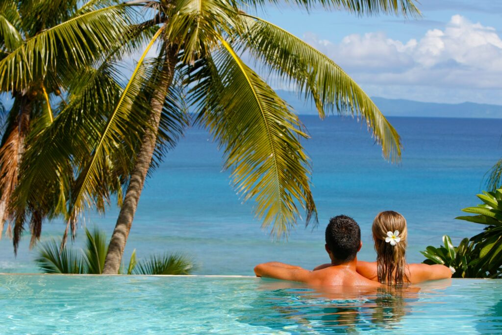 A couple in a private infinity pool overlooking the ocean.