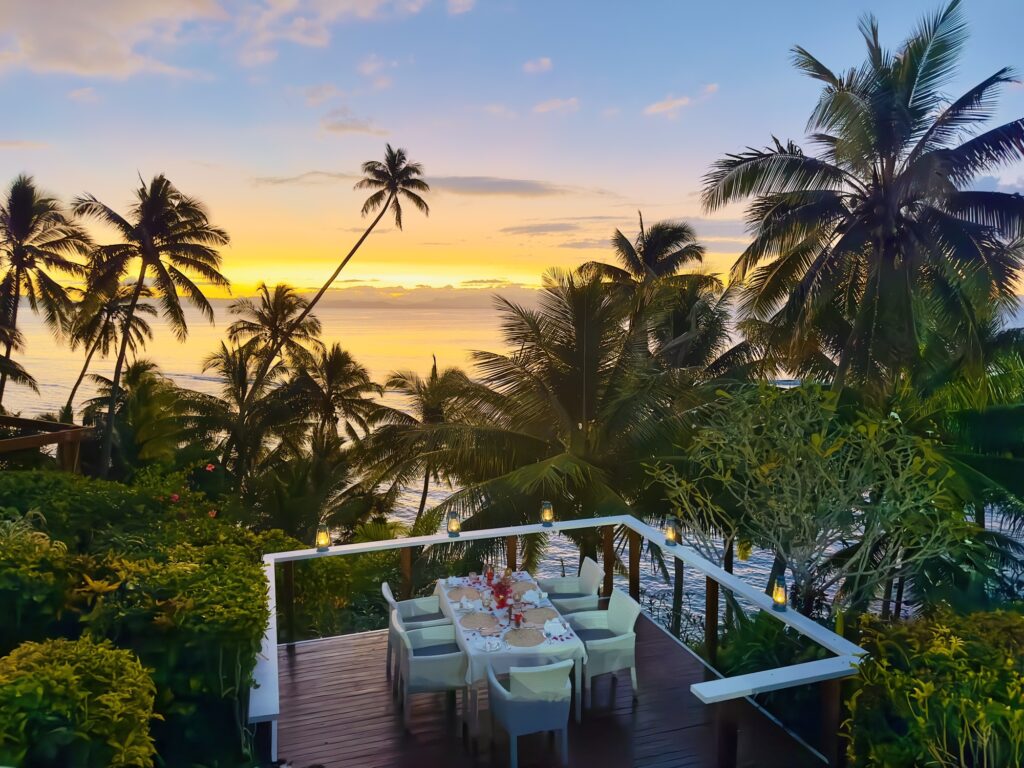 Sunset dining with palm trees.