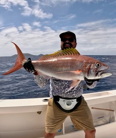 Angler holding red snapper on deep sea fishing charter Taveuni Island Fiji