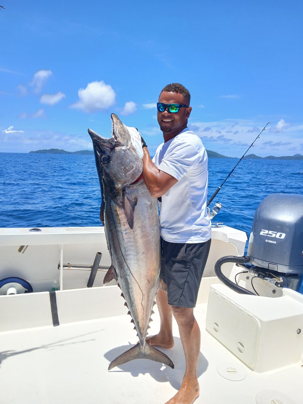 Angler holding dog tooth tuna